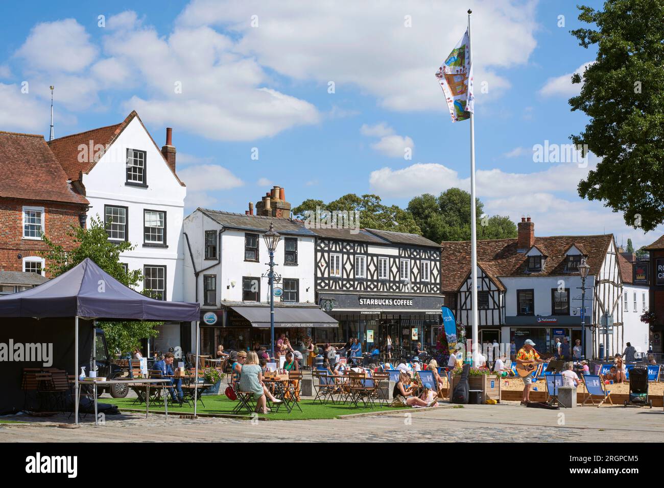 Old buildings and people sitting outside at Market Place, Hitchin, Hertfordshire, UK, in summertime Stock Photo