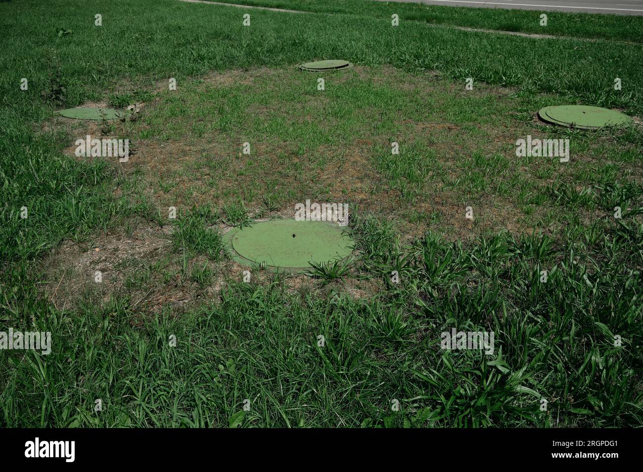 Green hinged cover sewer manhole. old design manhole covers, top view Stock Photo