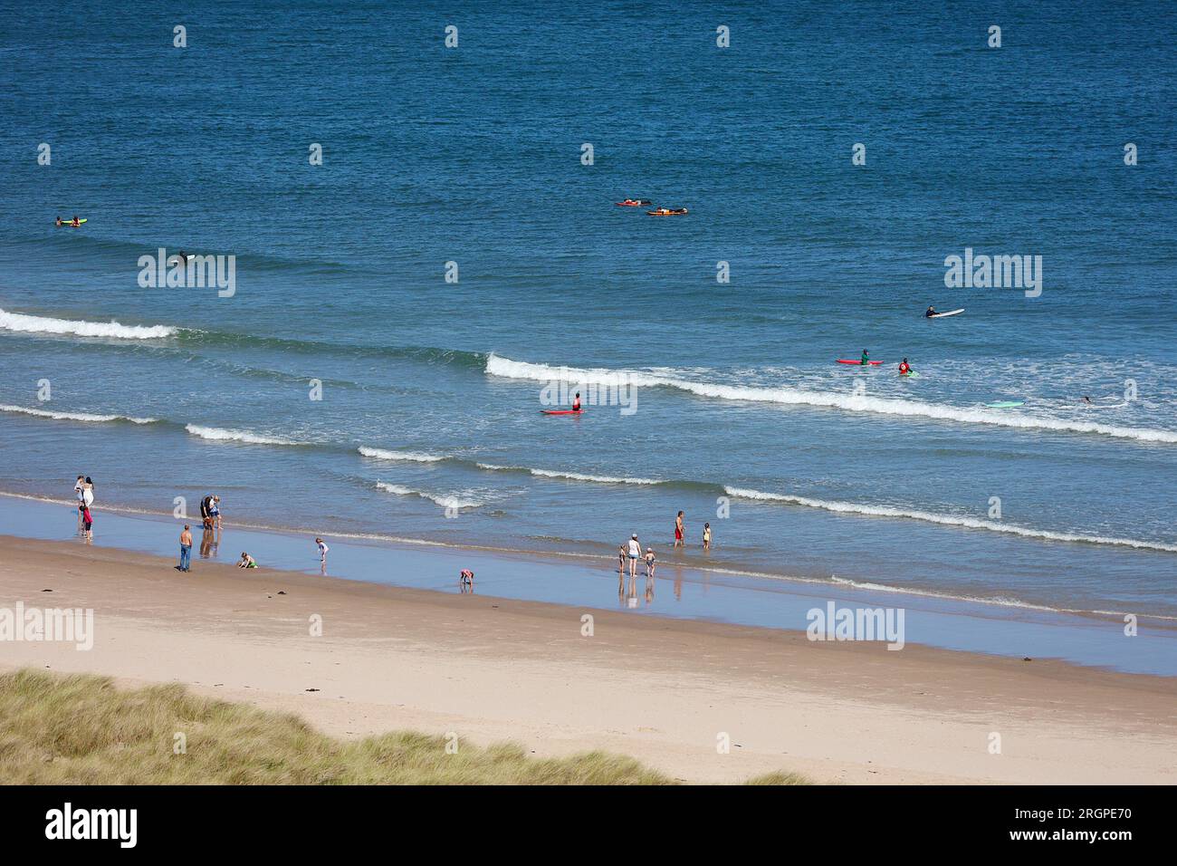 Bamburgh, Northumberland, UK. 11 August, 2023. UK Weather: A bright and Sunny day on Bamburgh beach as visitors and surfers enjoy the sunshine. Photo Credit: PAL News/Alamy Live News Stock Photo