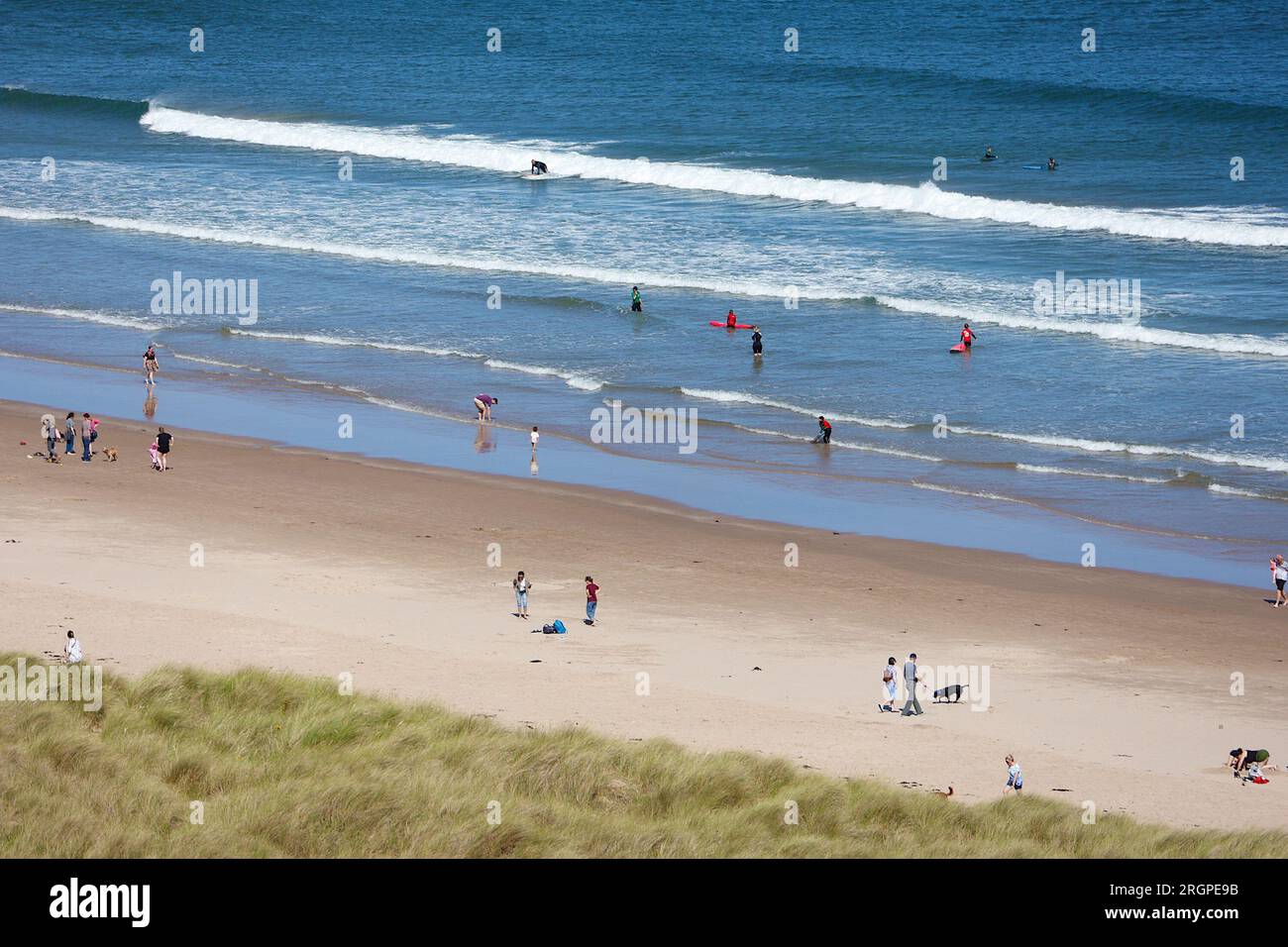 Bamburgh, Northumberland, UK. 11 August, 2023. UK Weather: A bright and Sunny day on Bamburgh beach as visitors and surfers enjoy the sunshine. Photo Credit: PAL News/Alamy Live News Stock Photo