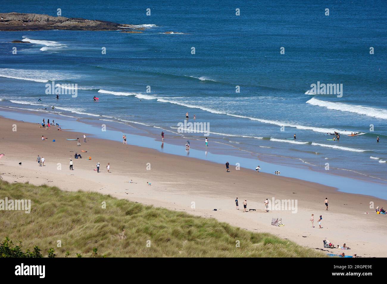 Bamburgh, Northumberland, UK. 11 August, 2023. UK Weather: A bright and Sunny day on Bamburgh beach as visitors and surfers enjoy the sunshine. Photo Credit: PAL News/Alamy Live News Stock Photo