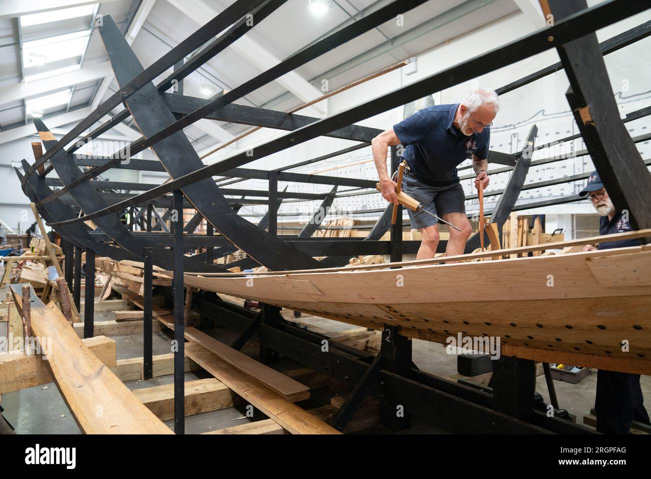 Mike Pratt and David Steptoe work on the replica of the Sutton Hoo longship, at the Longshed in