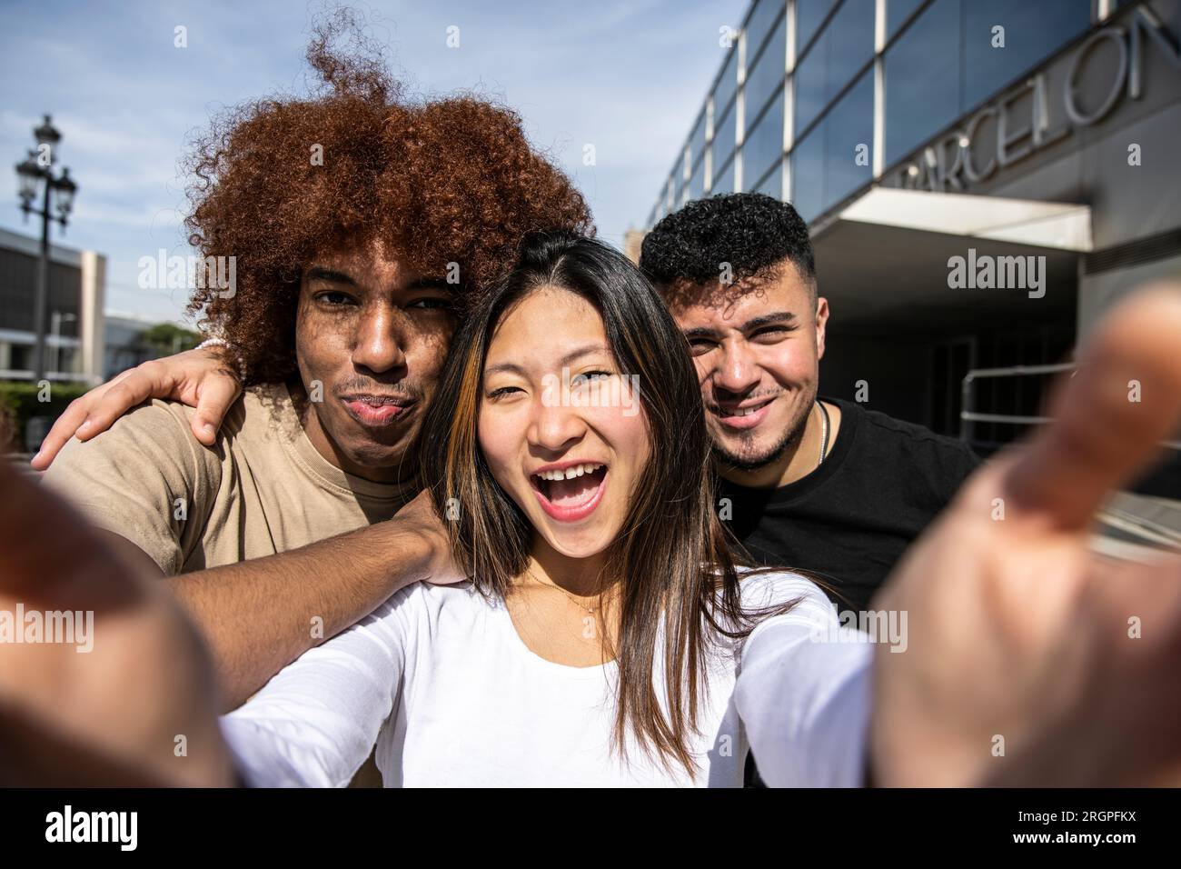 Three young diverse people taking a selfie with a smartphone looking at ...