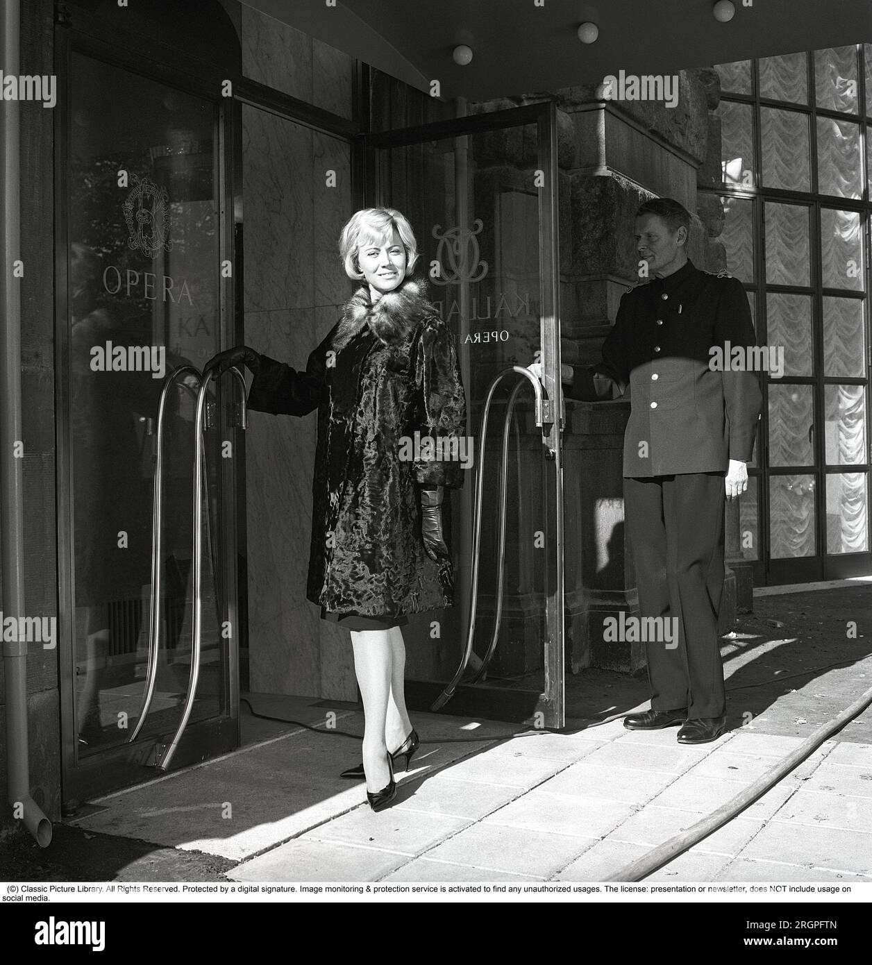 Service in the 1960s. A young fashionable dress woman is standing in the doorway of restaurant Operakällaren in Stockholm with a doorman galantly holding the door up.  Sweden 1962. Kristoffersson Ref CV87-6 Stock Photo