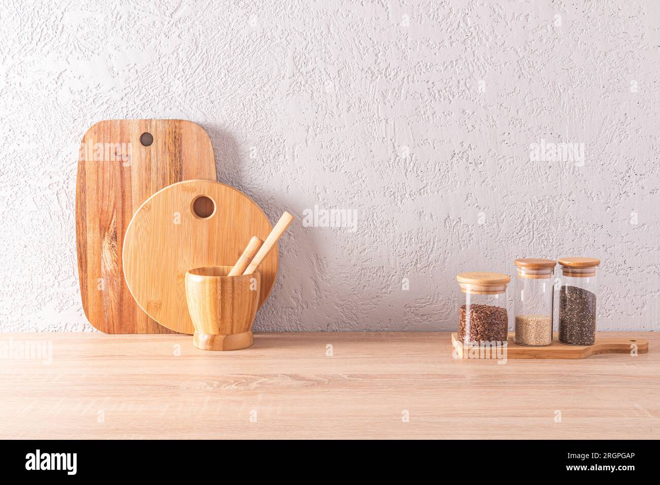 https://c8.alamy.com/comp/2RGPGAP/front-view-of-the-wooden-countertop-of-an-eco-friendly-kitchen-with-jars-for-storing-bulk-products-and-cutting-boards-space-for-text-2RGPGAP.jpg