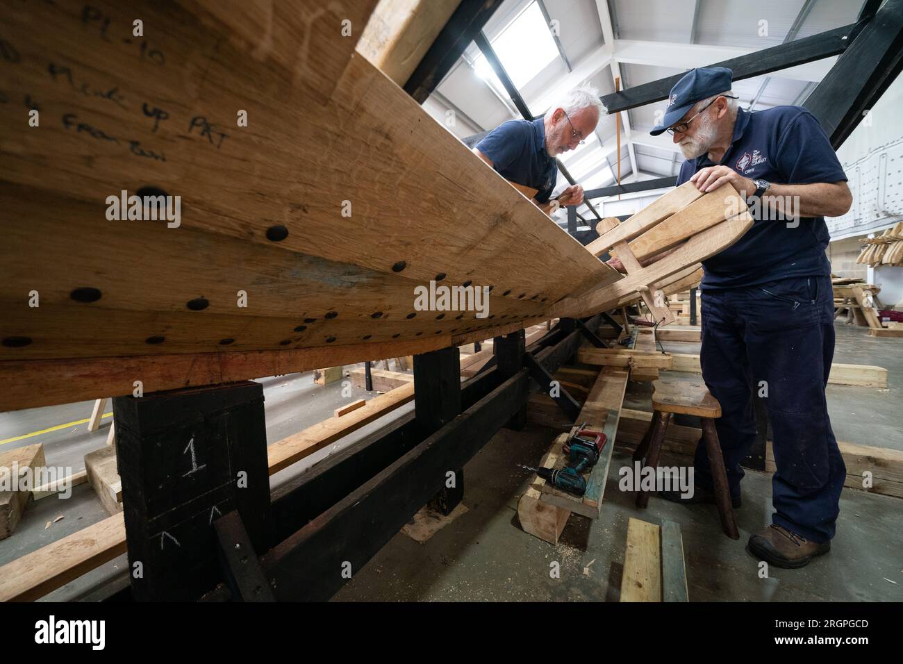 Mike Pratt and David Steptoe work on the replica of the Sutton Hoo longship, at the Longshed in