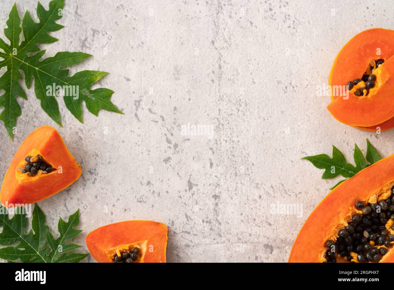 Cut Papaya over gray table background for tropical fruit design concept, top view copy space. Stock Photo