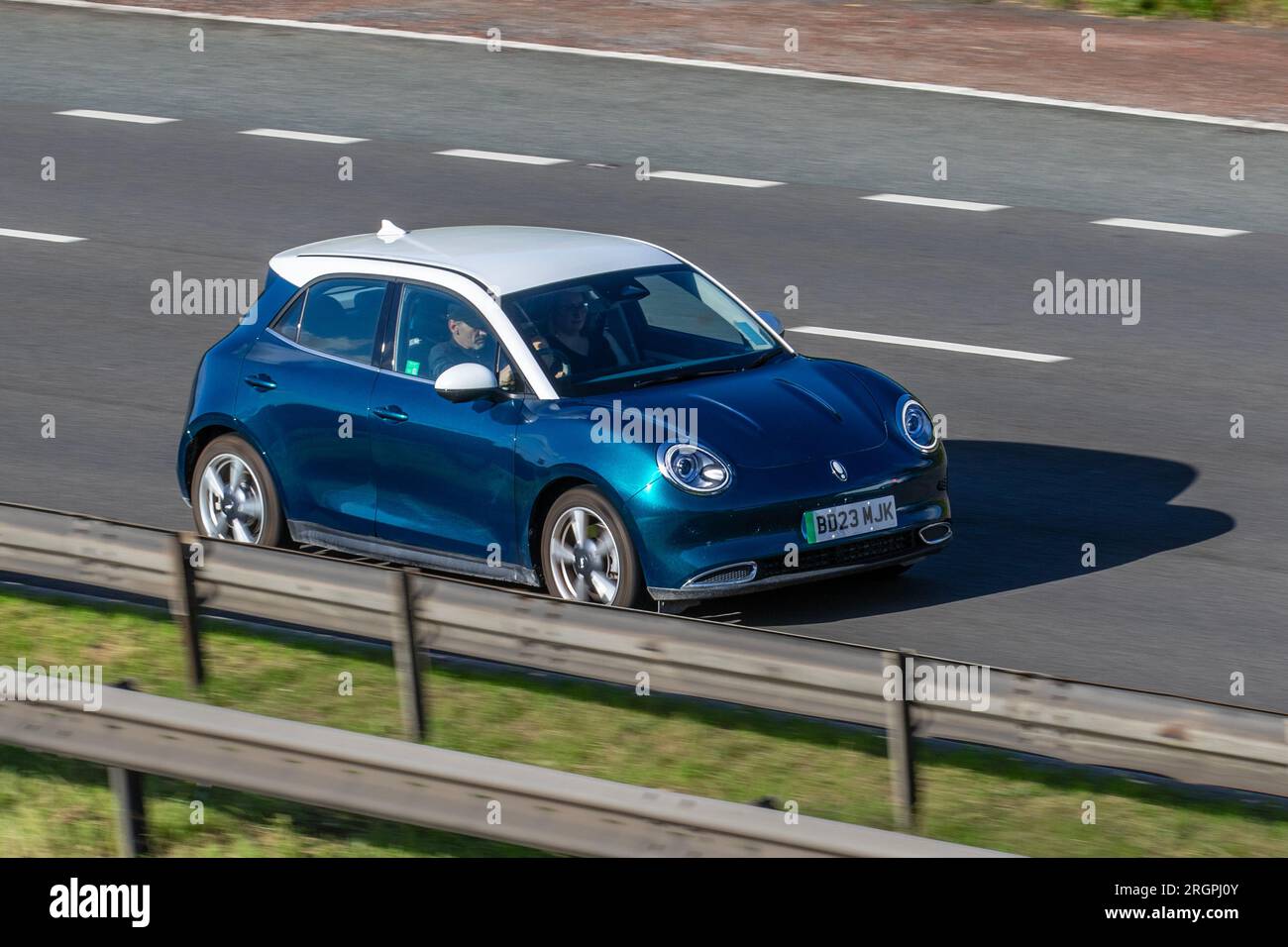 2023 ORA Funky CAT First Edition,  Blue with white roof cap, 401 km battery-only ; travelling at speed on the M6 motorway in Greater Manchester, UK Stock Photo