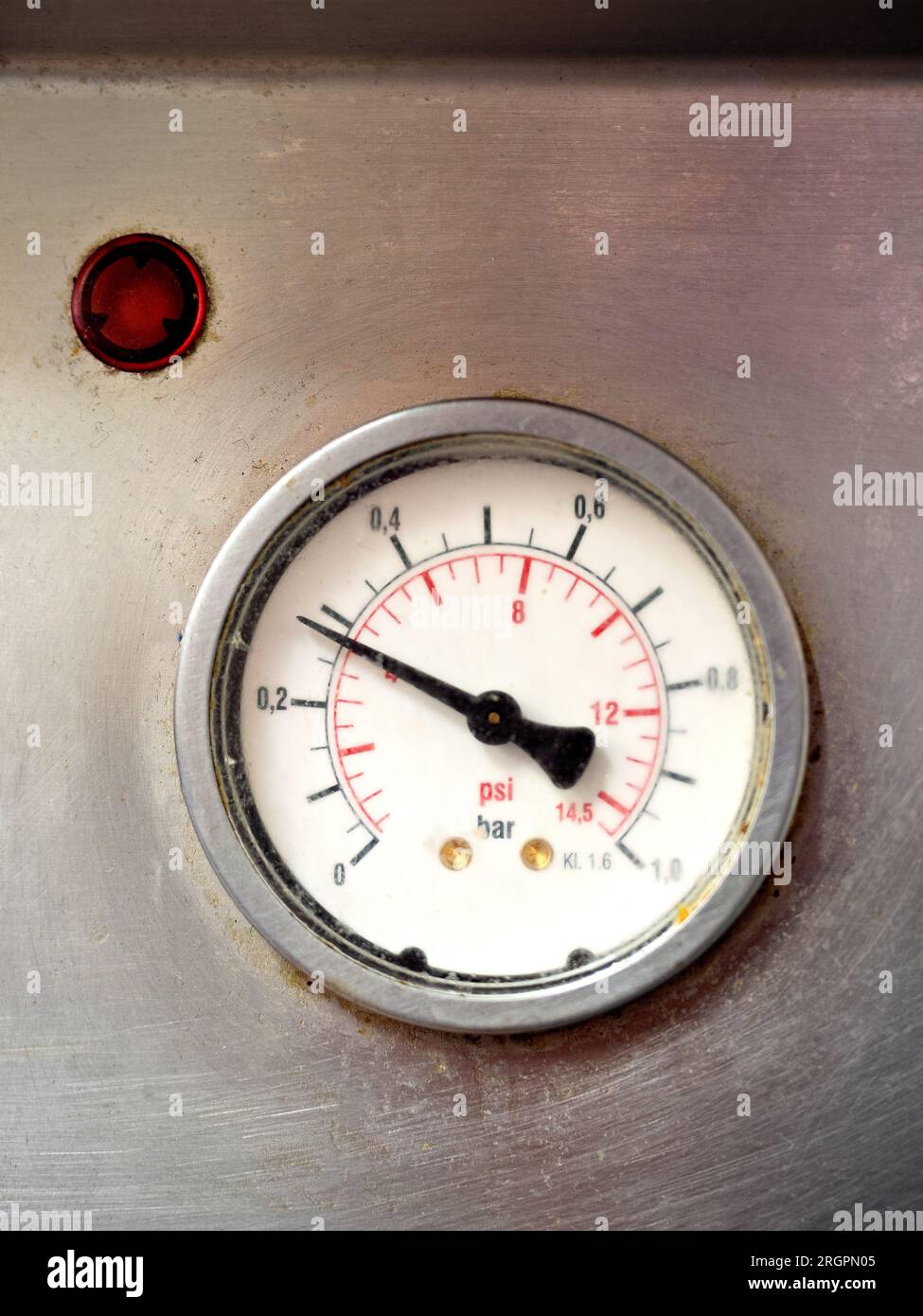 Steam pressure gauge measure showing current bar of the machine with red over pressure warning light Stock Photo