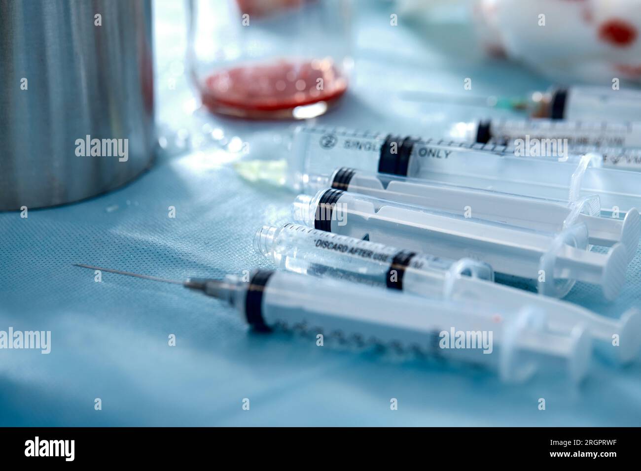 Many syringes on a blue sheet in operation room. Different sizes of