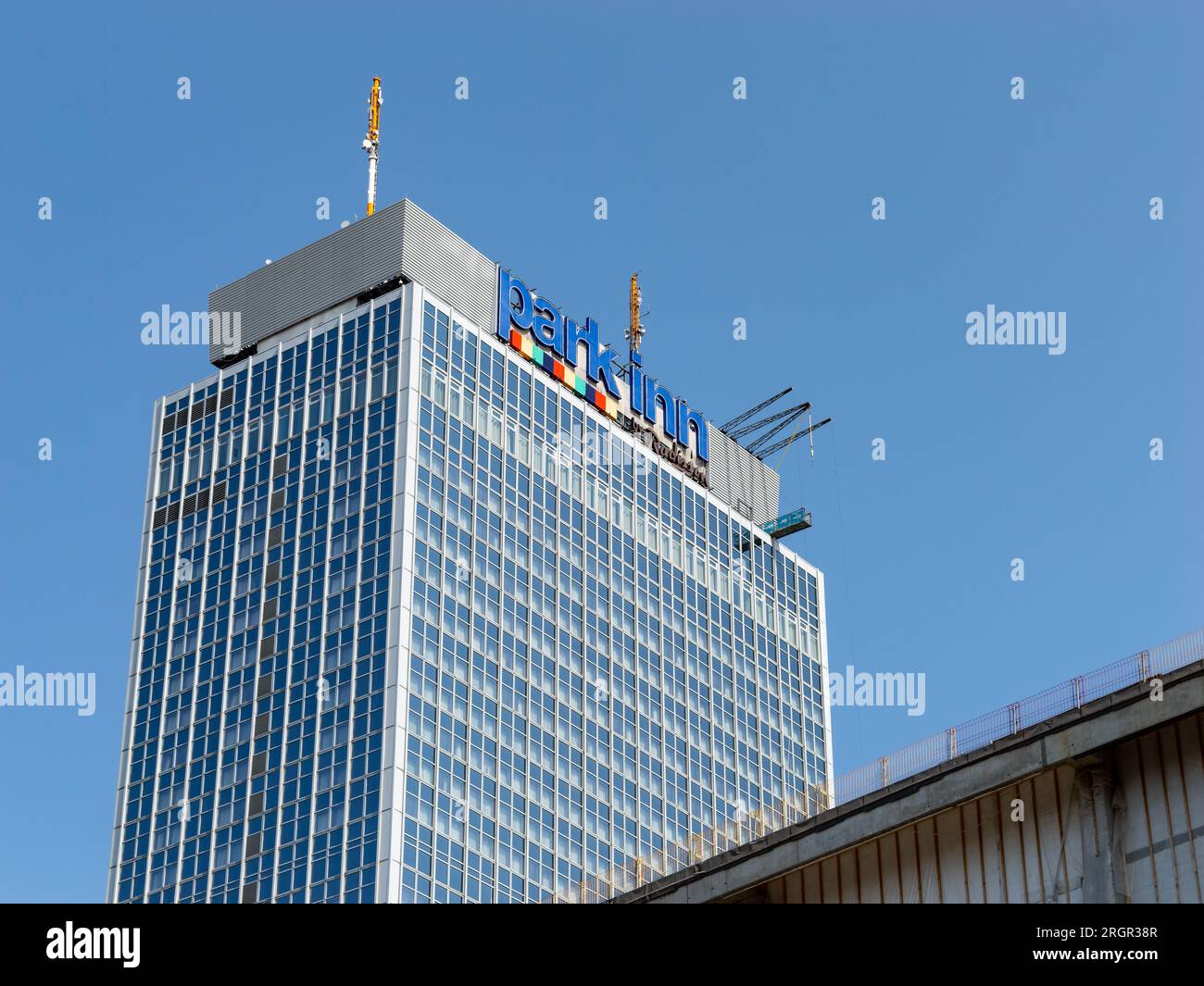 Park Inn hotel at the Alexanderplatz. The high rise building with the logo sign on the top is viewed from a low angle. It belongs to Radisson. Stock Photo