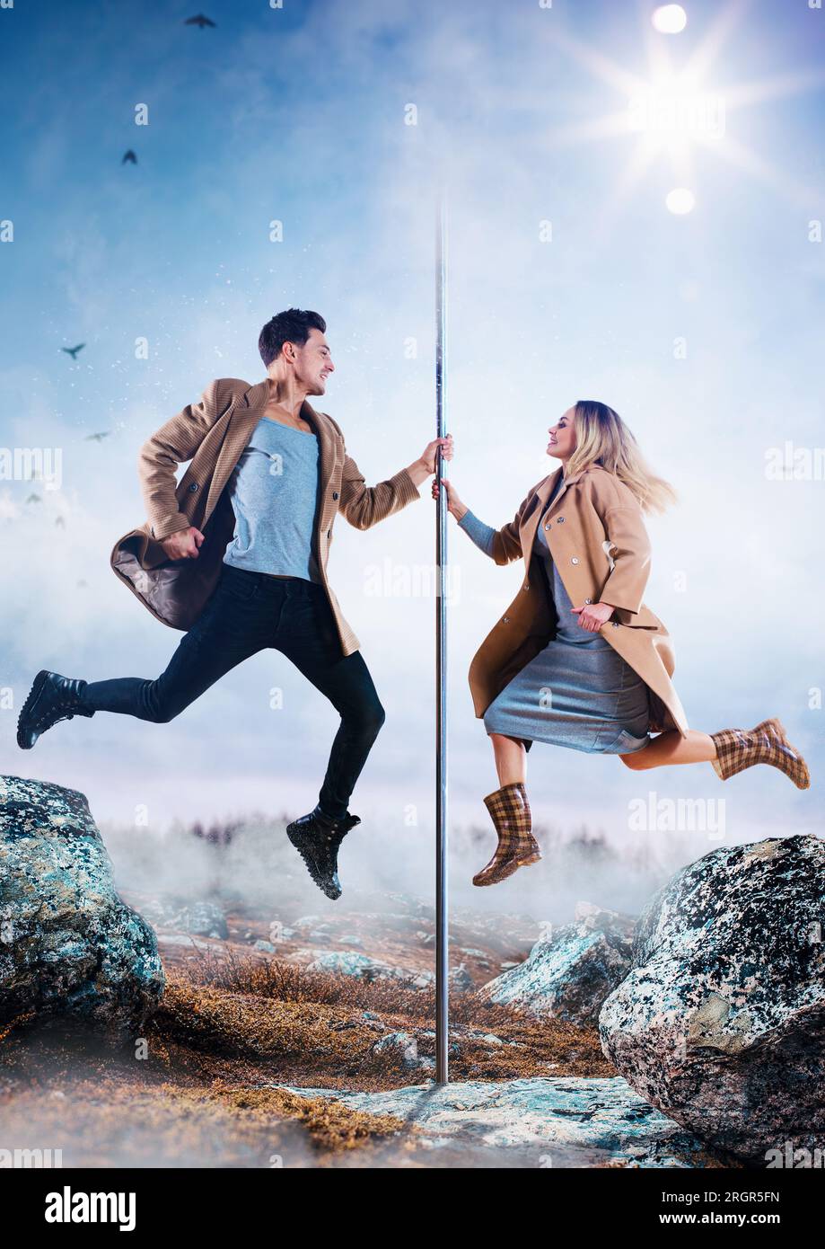 Young man and woman pole dancers in casual autumn clothing jumping, creative concept Stock Photo