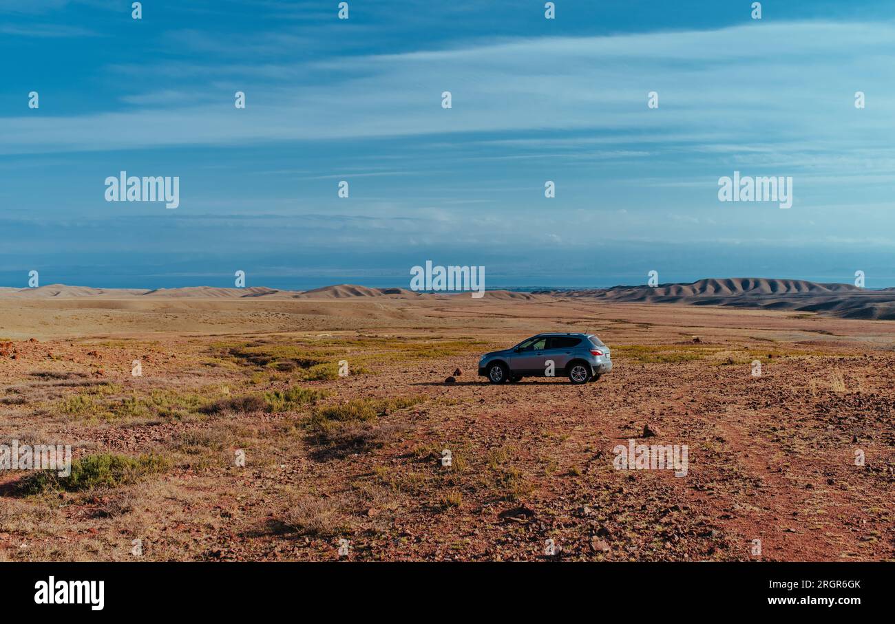 Car on plain in the mountains in spring Stock Photo