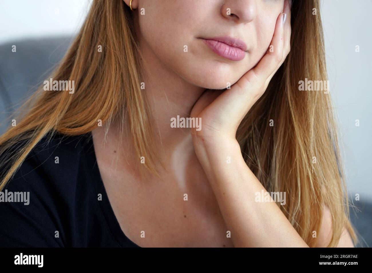 Girl with her face resting on her hand. Toothache. Depression. Mental health. Stock Photo