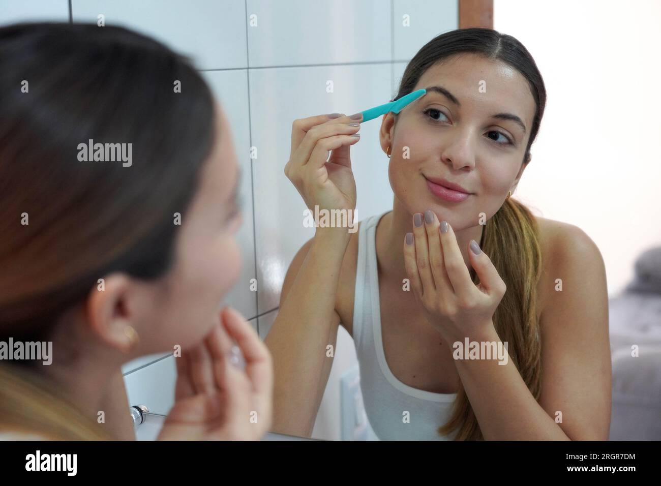 Facial hair removal. Closeup of beautiful young woman shaving her face