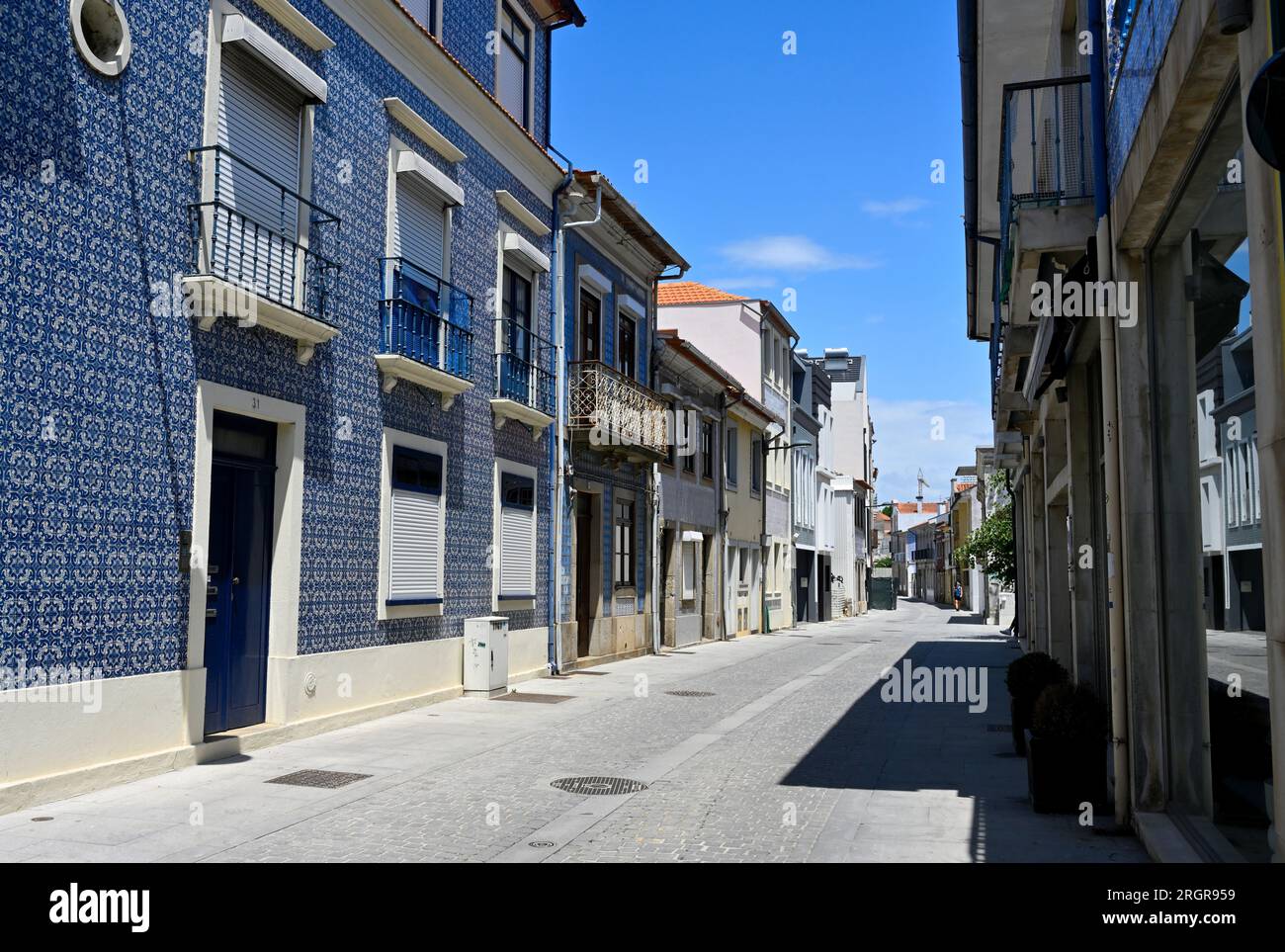 Small residential street in Aveiro, Portugal with building tilled in traditional Portuguese manor, windows shuttered to keep heat out Stock Photo