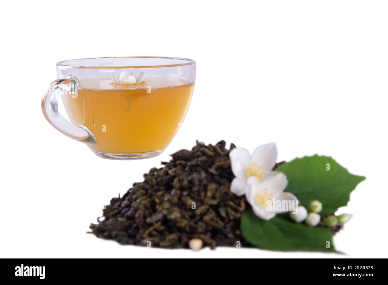 Dried tea leaves, fresh jasmine blossoms with green leaf and glass tea