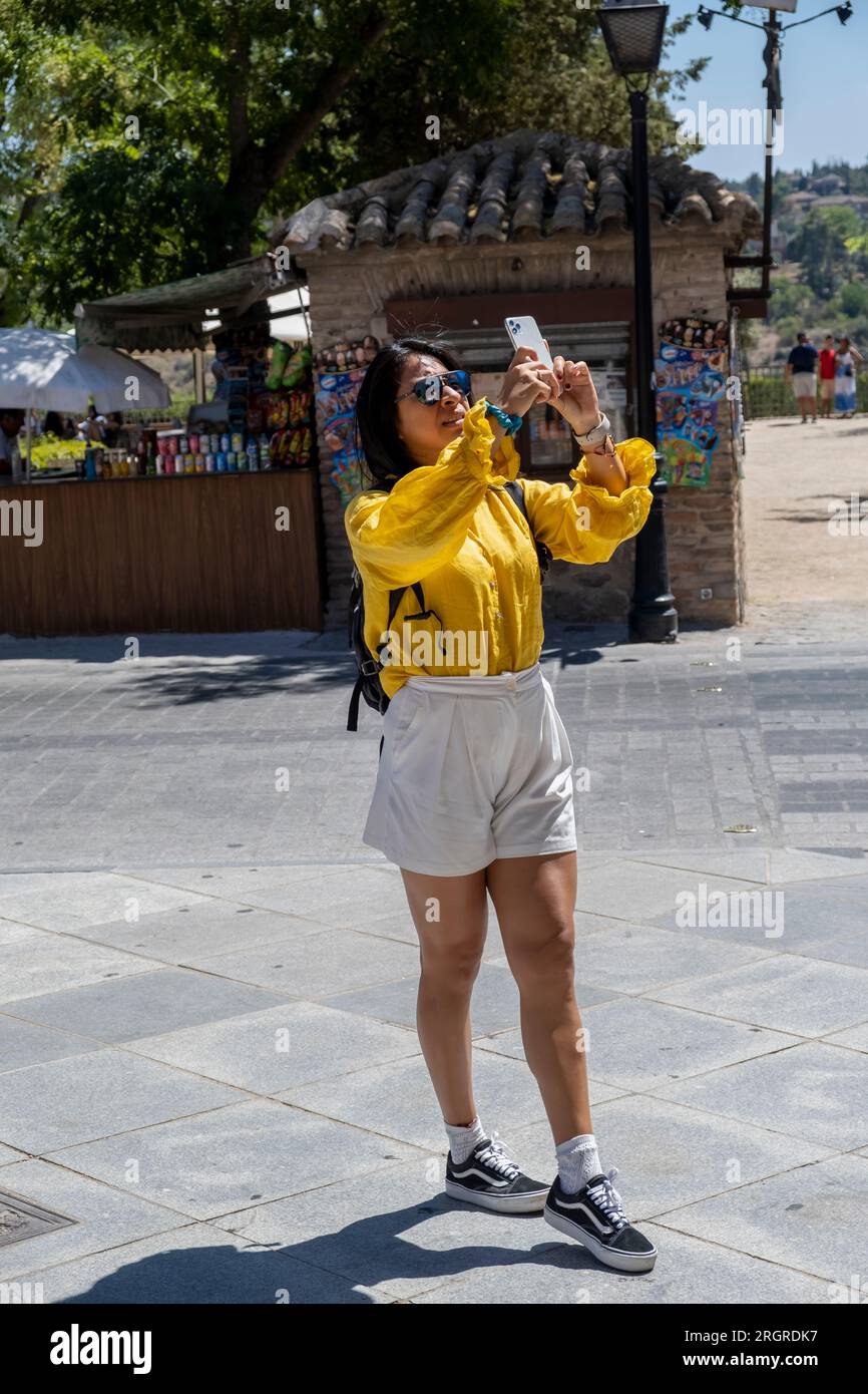 Mexican woman taking photo at the medieval city of Toledo, Spain Stock ...