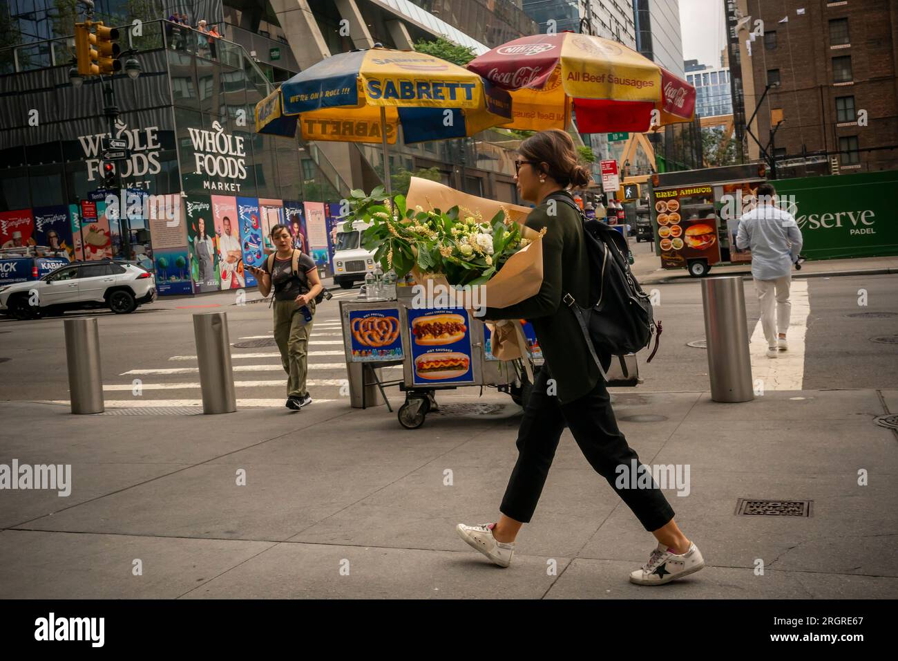 A woman carries a bouquet of flowers in the Hudson Yards neighborhood in New York on Friday
