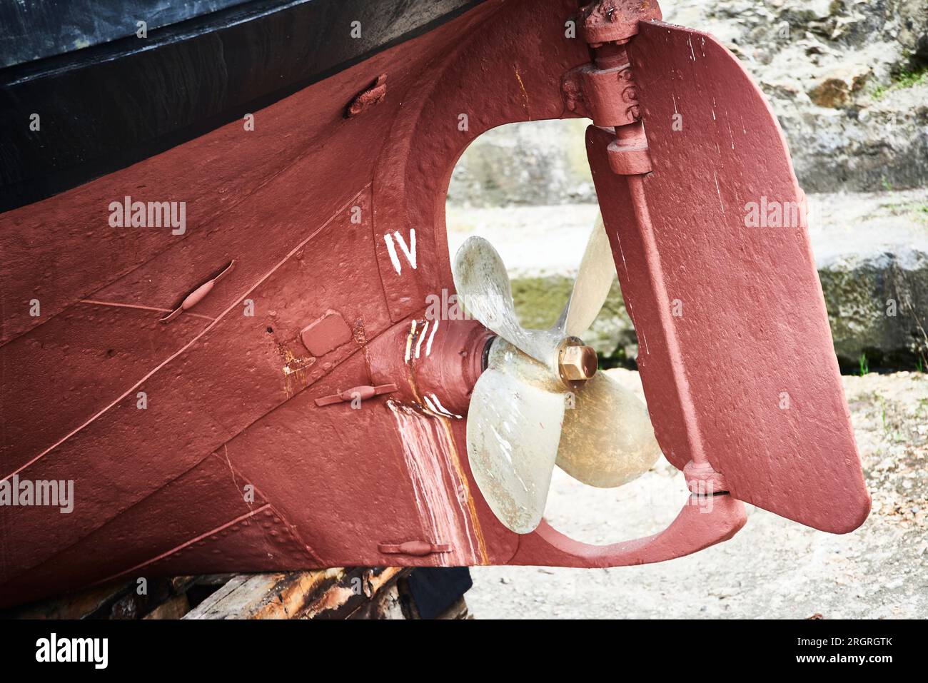 Detail of red ship hull and propeller in a Shipyard. Stock Photo