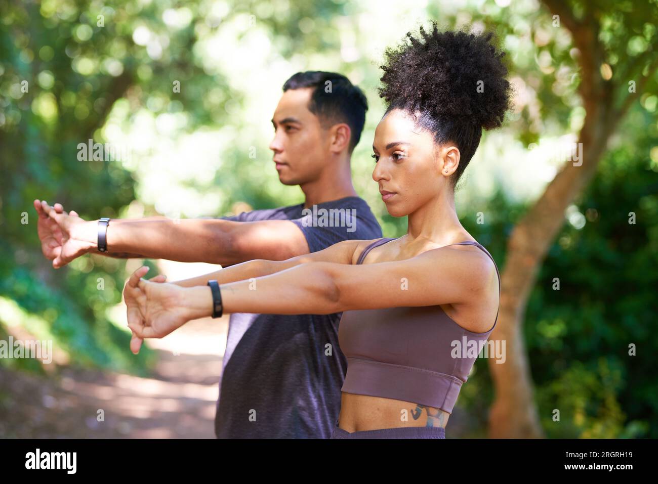 Serious couple stretch together before trail run in forest, fitness ...