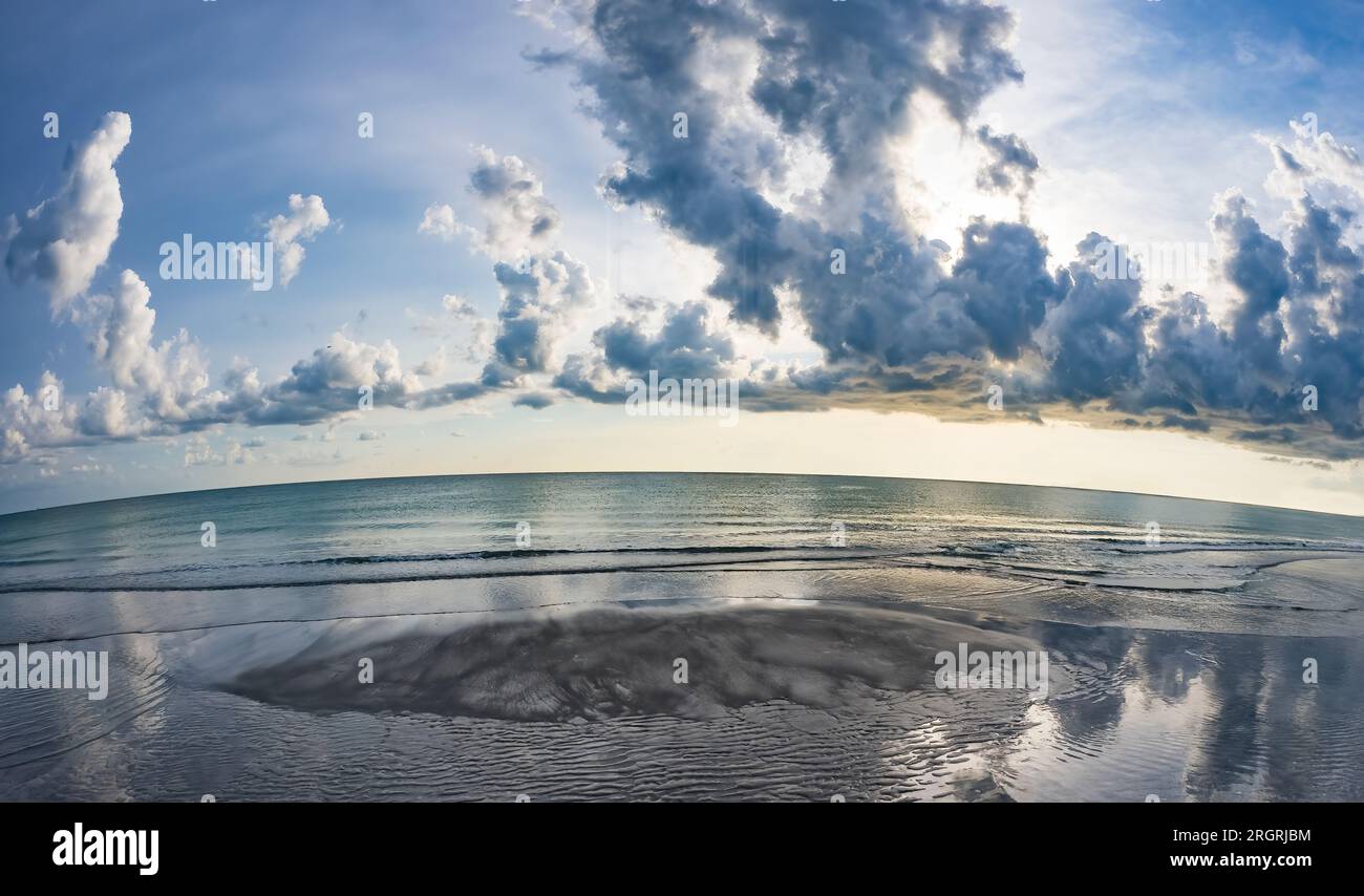 Fisheye lens view of late afternoon sun and clouds over the Gulf of Mexico from Venice Beach in Venice Florida USA Stock Photo