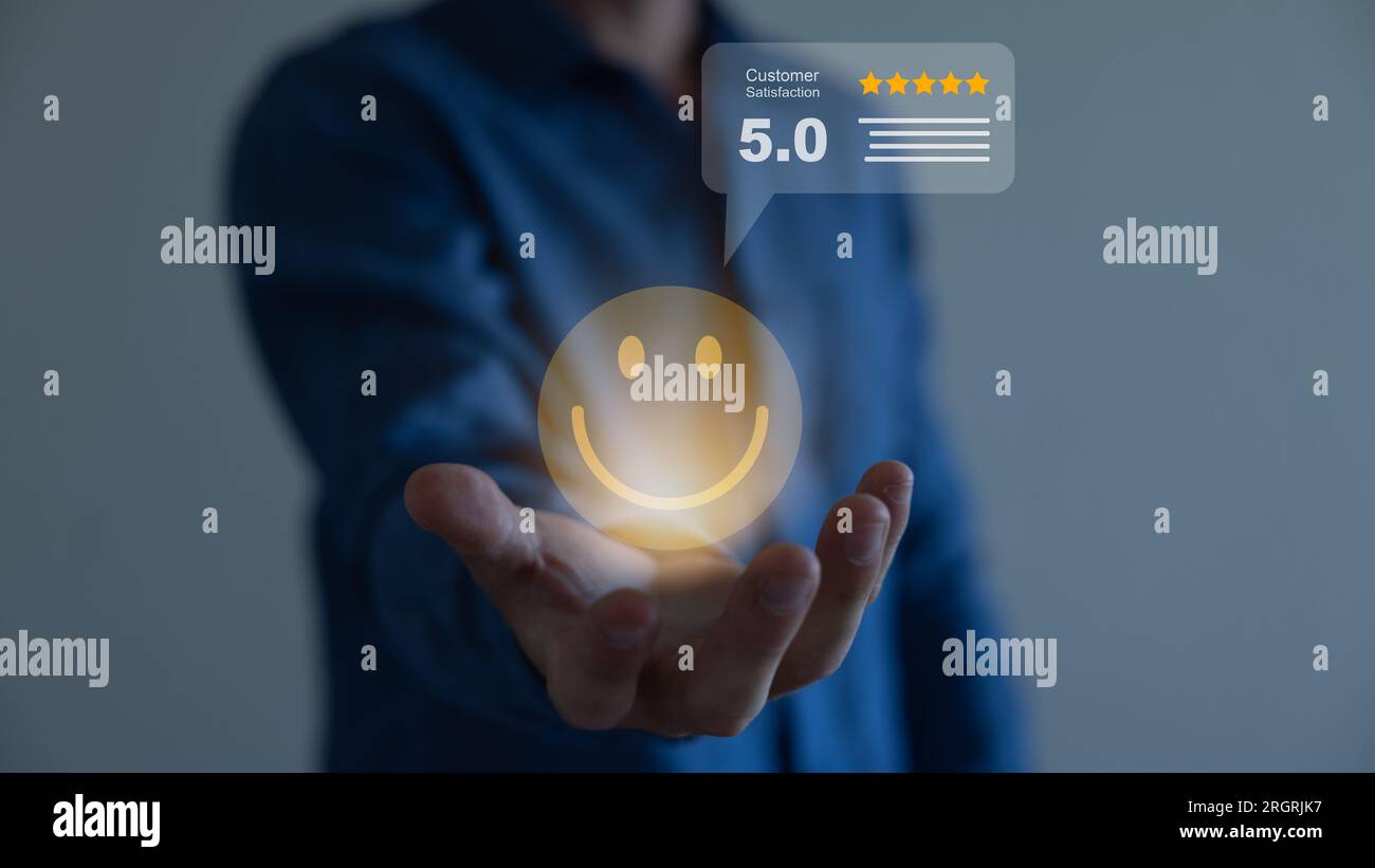 Businessman holding virtual smiley face with five stars and using ...