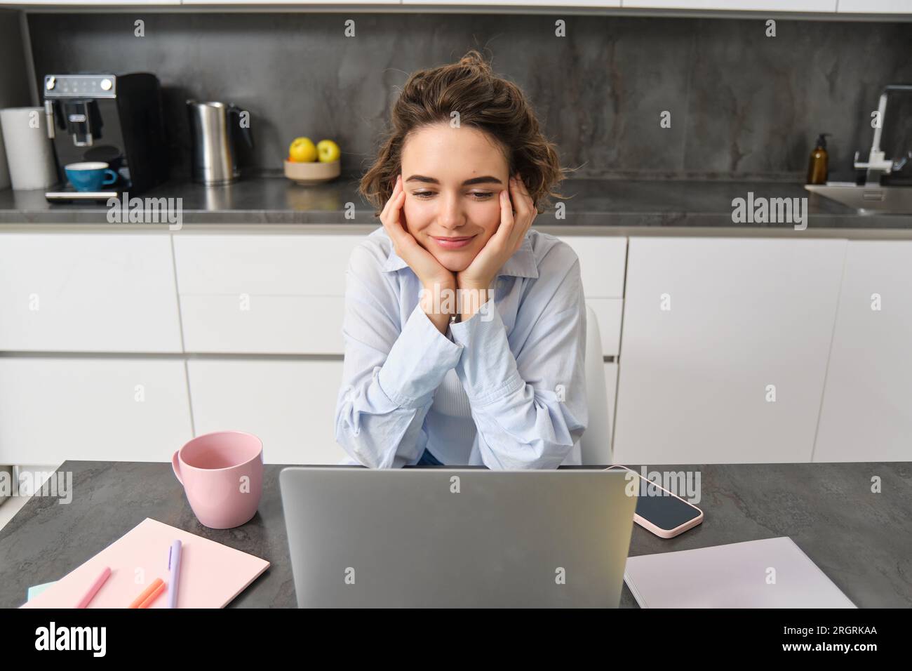 Portrait of young woman watching video on laptop, looking at computer ...