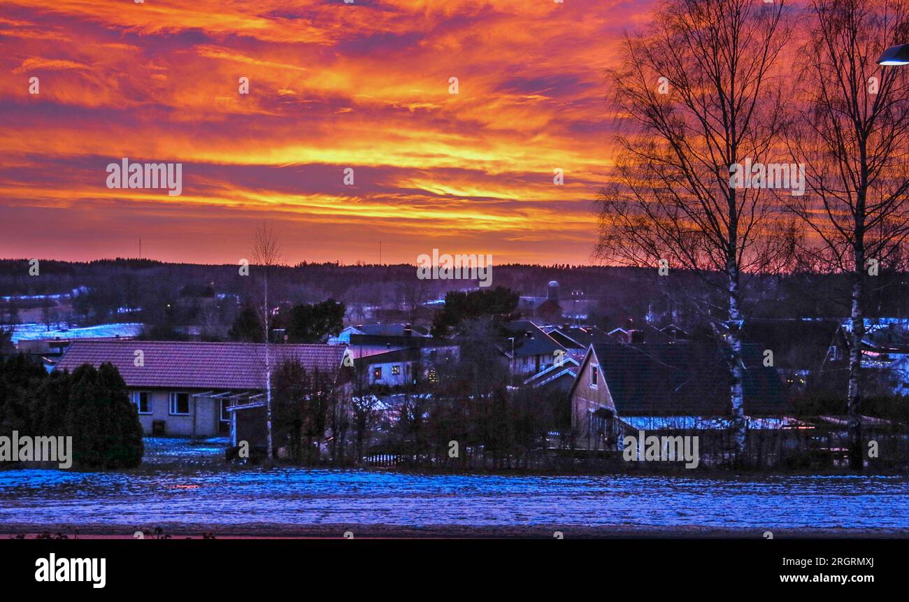 RED WINTER SKY over the villas in the dim dusk light Stock Photo