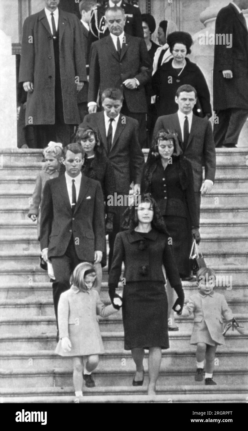 Washington, D.C.:  November 24, 1963 Mrs. John F. Kennedy walks down the Capitol steps with her daughter Caroline and son John Jr. after the slain President's casket was placed in the rotunda today. At left, from top: President Johnson, Peter Lawford, Mrs. Stephen Smith and Sydney Lawford, and Atty. Gen. Robert Kennedy. Right, from top: Mrs. Lyndon Johnson, Stephen Smith and Mrs. Lawford. Stock Photo