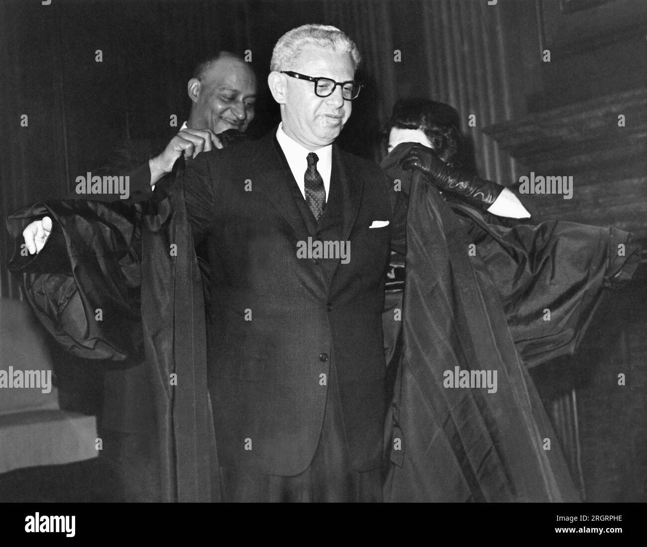 Washington, D.C.:  October 1, 1962 Former Labor Secretary Arthur J. Goldberg gets an assist with his robes as he prepares to get sworn in as the replacement for Justice Felix Frankfurter on the U.S. Supreme Court. Stock Photo
