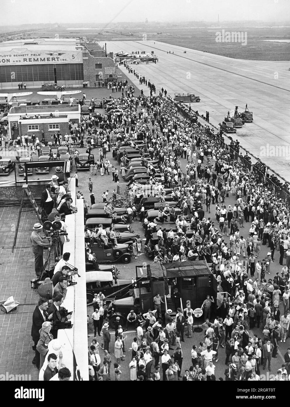 New York, New York:  July 14, 1938 Part of the huge crowd on hand at Floyd Bennett Airport in Brooklyn when Howard Hughes landed his Lockheed 14N Super Electra airplane after leaving there and flying around the world in a new record of 3 days, 19 hours and 14 minutes, breaking Wiley Posts's record. Stock Photo