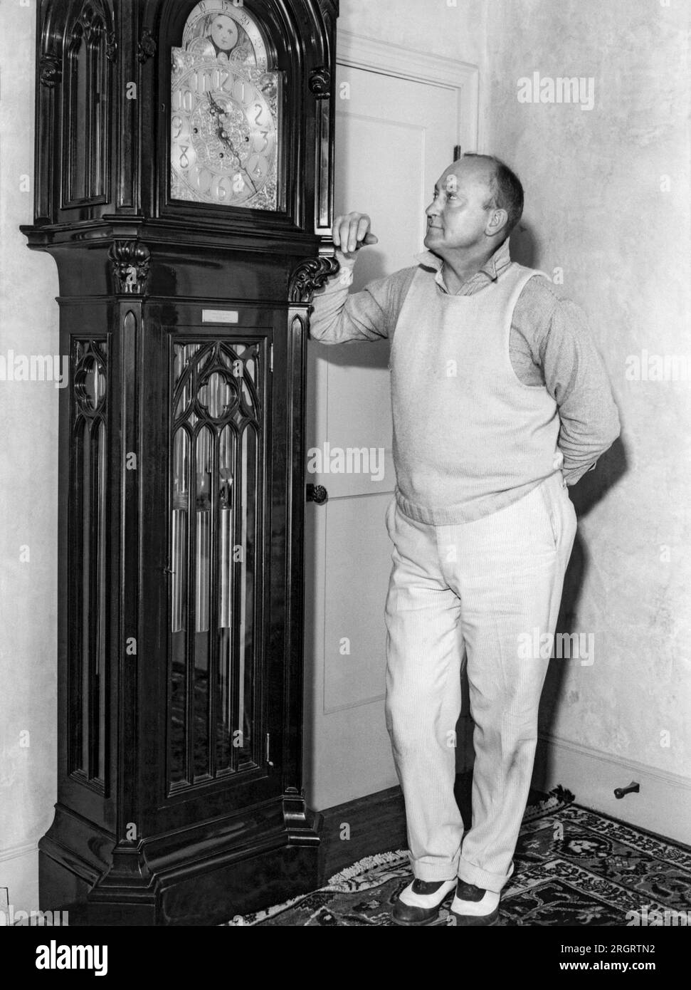 Atherton, California:  July 11, 1936 Baseball star Ty Cobb admires a grandfather clock at his home. Stock Photo