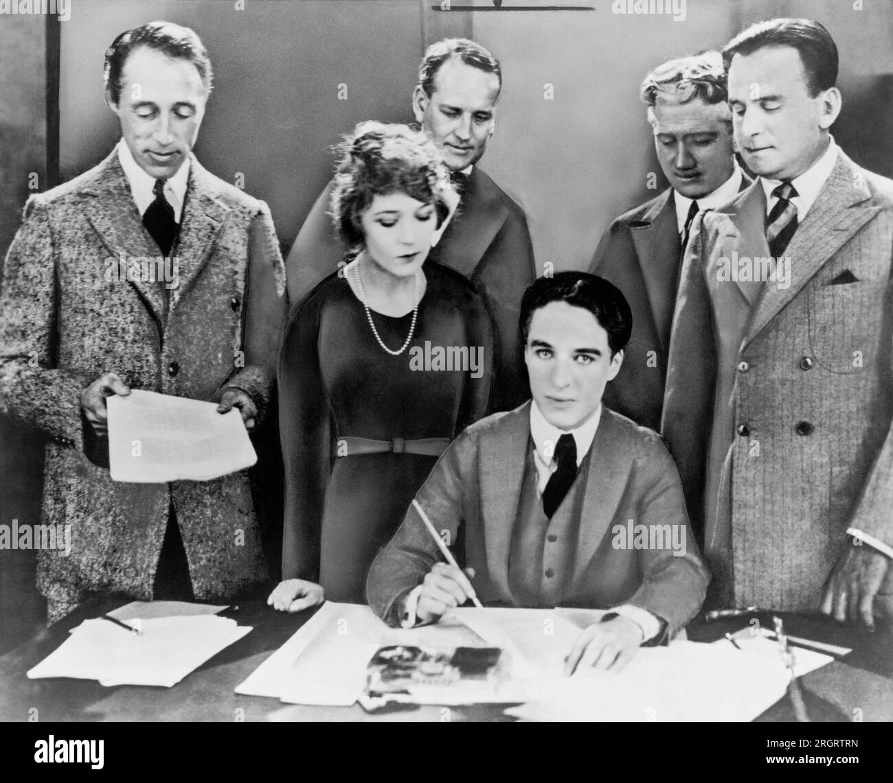 Hollywood, California:  April 17, 1919 The creation of the United Artists Corporation. The founders from left to right: D.W. Griffith,  Mary Pickford,  Charlie Chaplin and Douglas Fairbanks at the signing of the contract. Attorneys Albert Banzhaf and Dennis O'Brien are standing in the back. Stock Photo