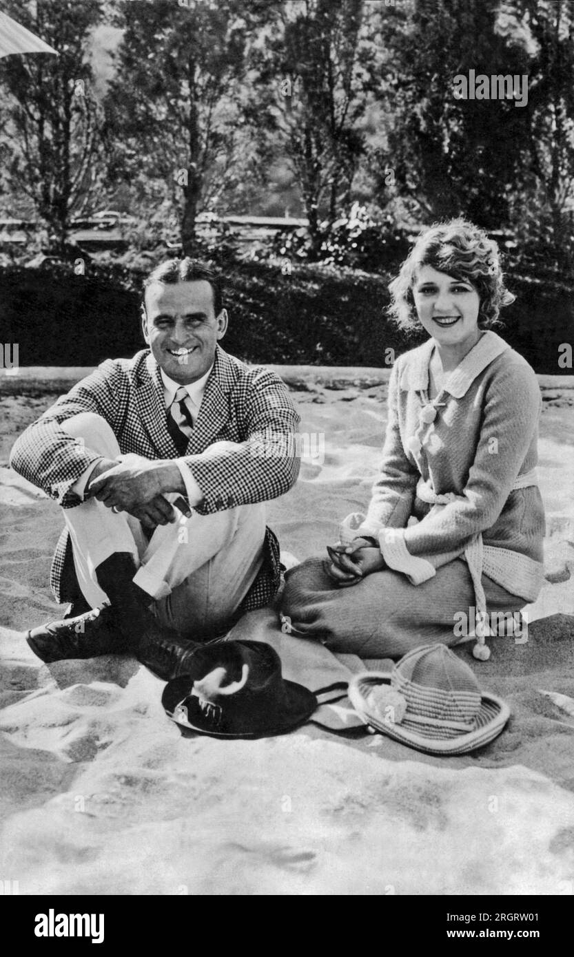 California:   c. 1926 Douglas Fairbanks and Mary Pickford relaxing on a sandy beach. Stock Photo