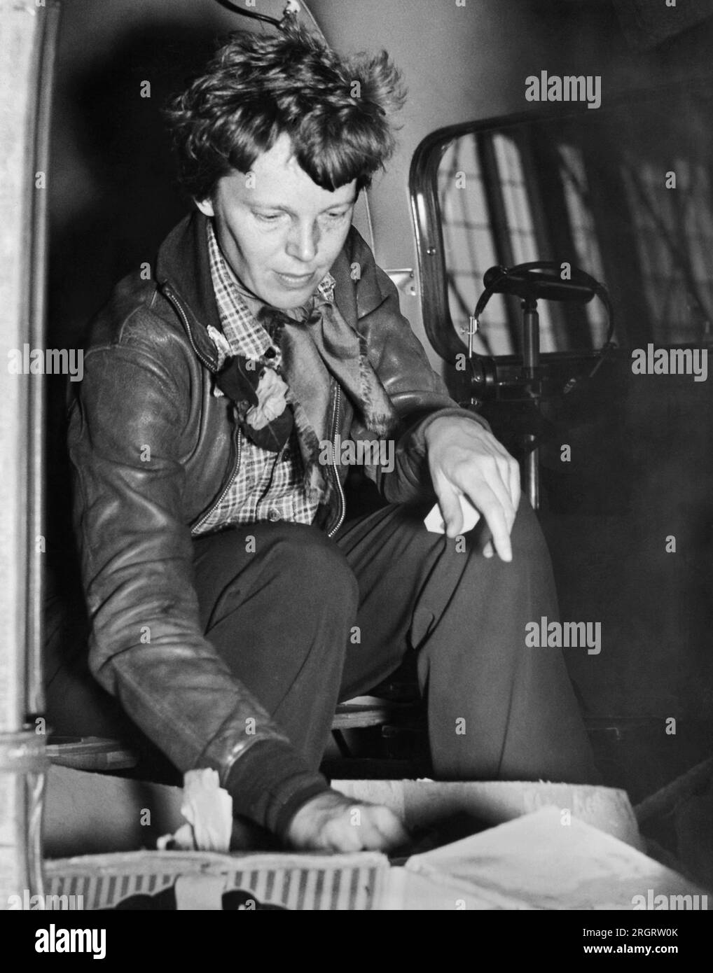 Oakland, California:  March 14, 1937 Aviatrix Amelia Earhart checks her cockpit supplies for her departure to Honolulu on the first leg of her globe circling flight. Stock Photo