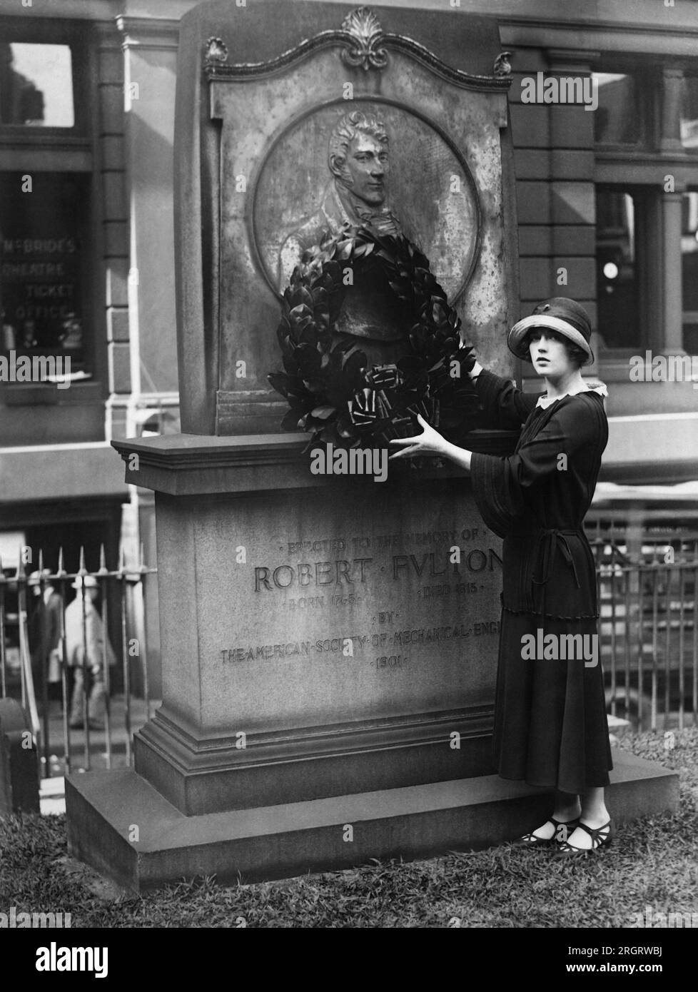 New York, New York:  August 17, 1923 Actress Marion Davies hangs a wreath on the monument for Robert Fulton in the Trinity Chuch courtyard. She is starring in the film, 'Little Old New York', which includes the scene of Fulton's steamship's inaugural voyage. Stock Photo