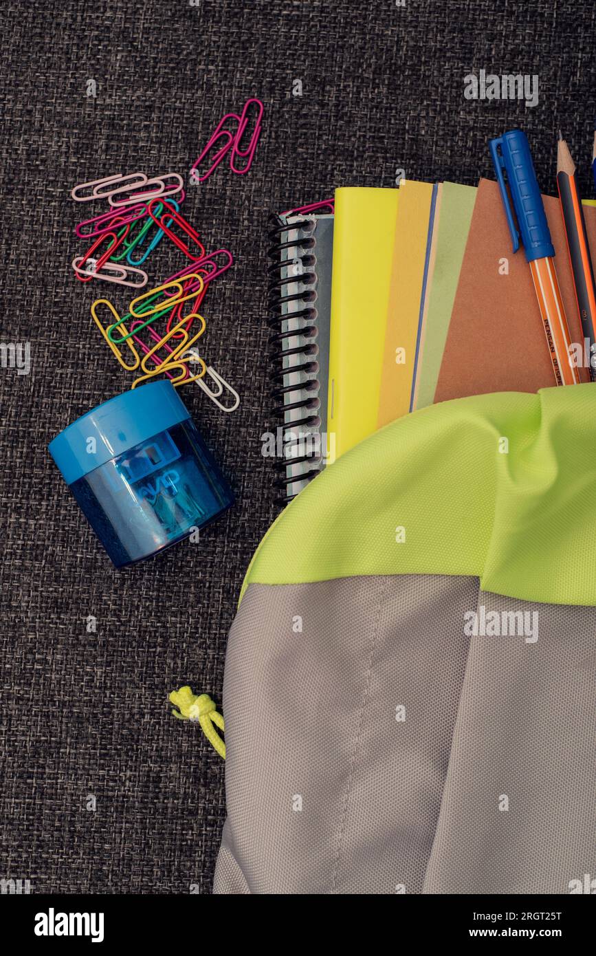 A school bag with school supplies for back to school concept on black surface Stock Photo