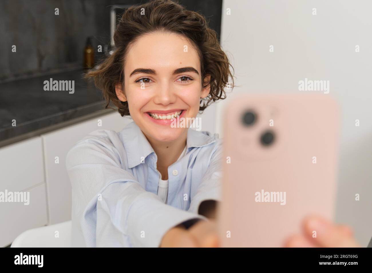 Portrait of beautiful young woman, taking selfie on mobile phone at ...