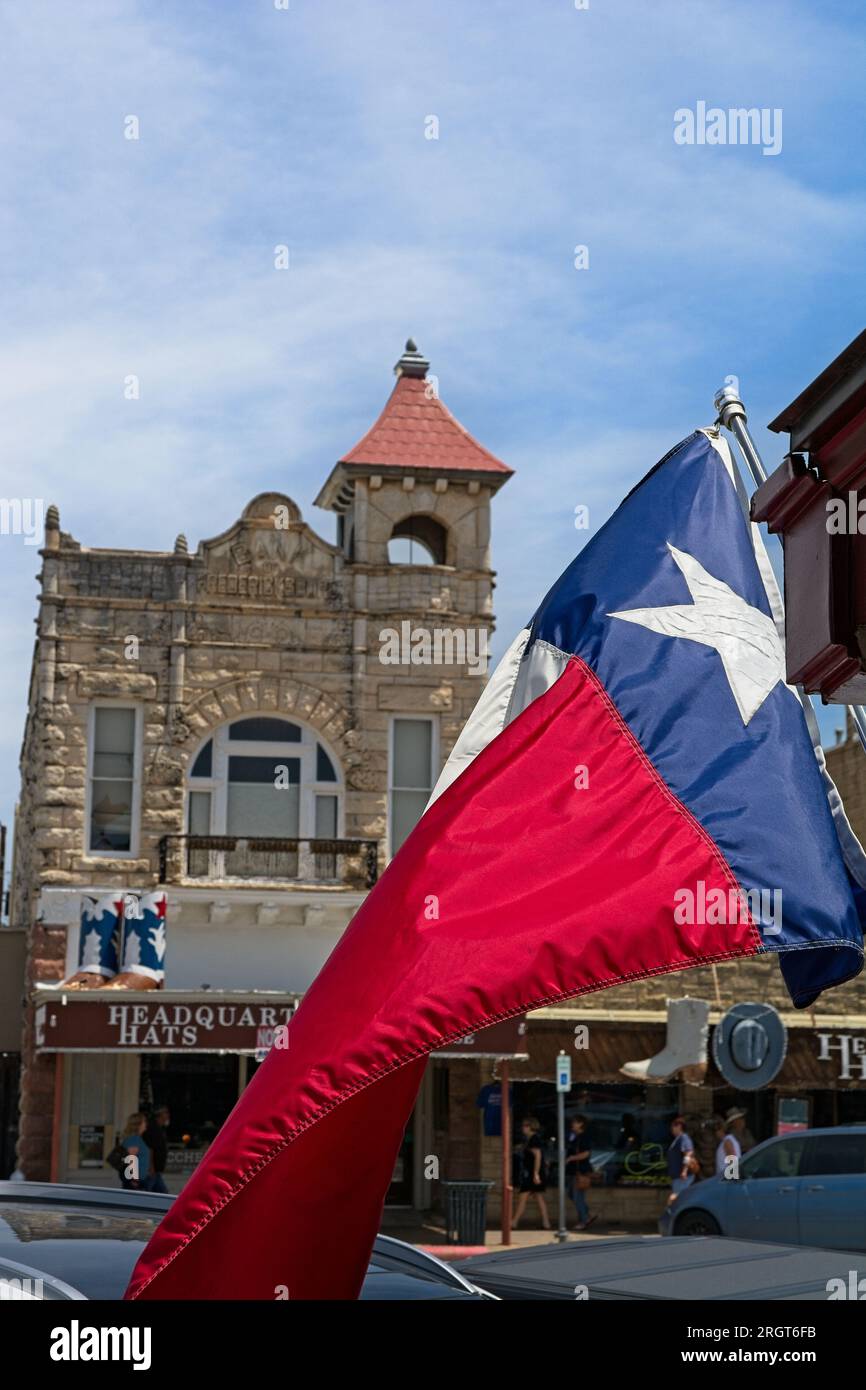 Texas flag waves over downtown commercial street with old