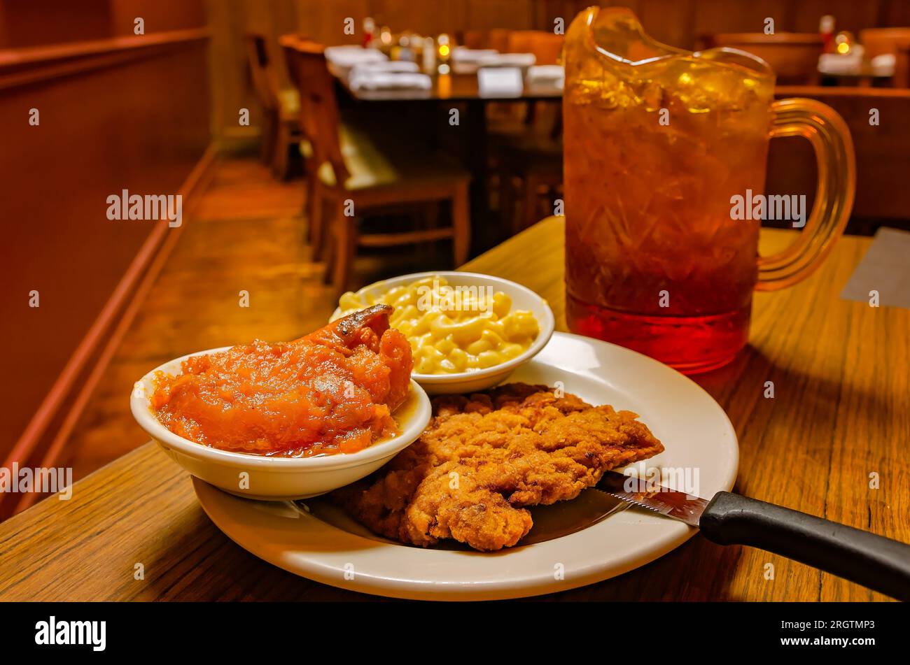Breaded fried chicken cutlet with candied yams and macaroni and cheese is served at Crystal