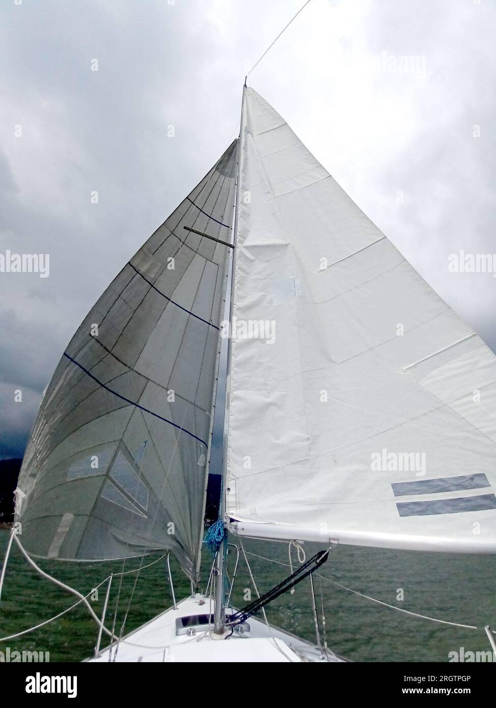Close up to parts of a sailboat that is sailing: mast, mainsail, sheet ...