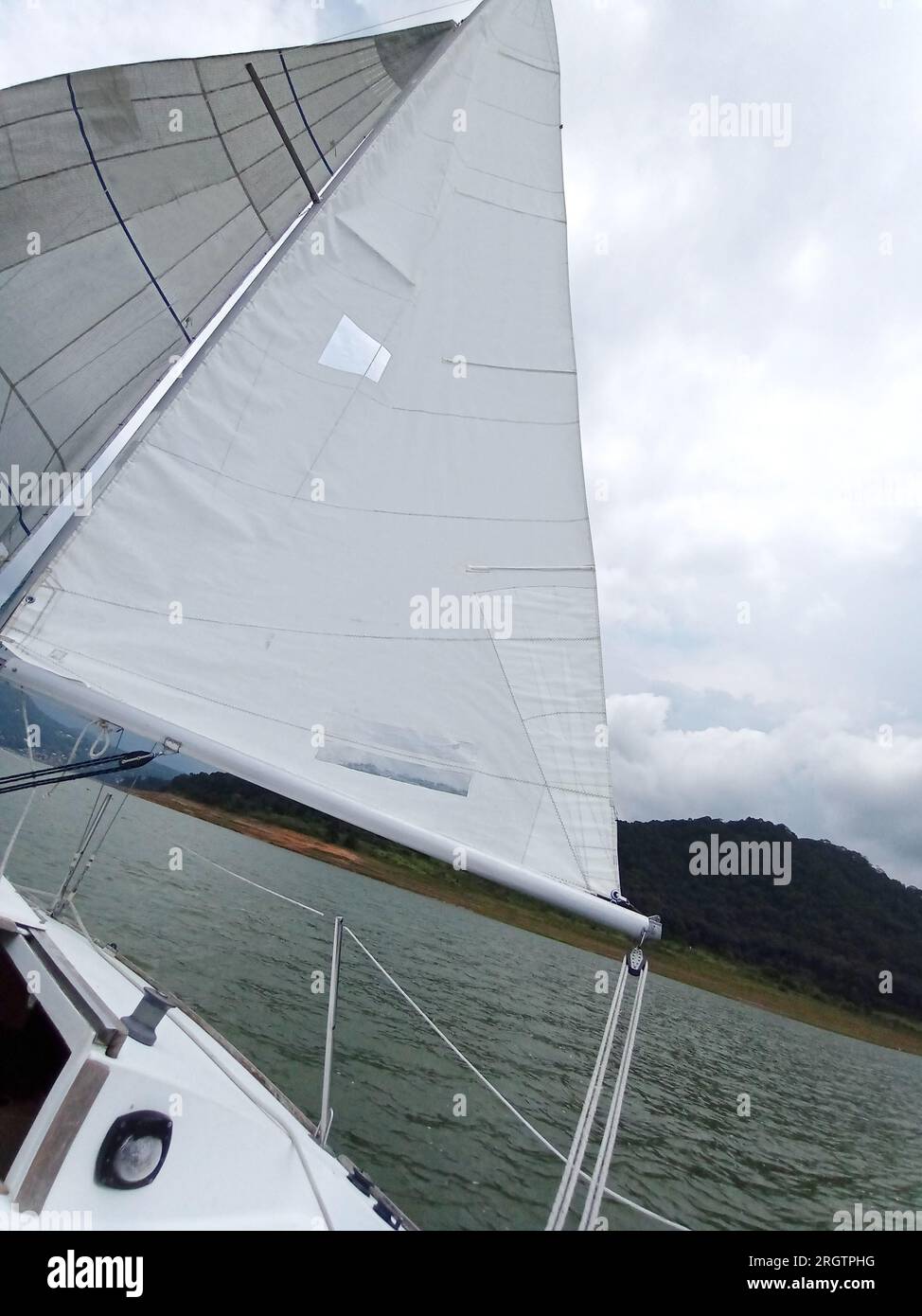 Close up to parts of a sailboat that is sailing mast, mainsail, sheet
