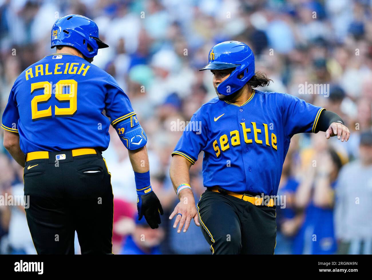 Seattle Mariners' Cal Raleigh (29) is greeted by Eugenio Suárez after  hitting a two-run home run against Baltimore Orioles starting pitcher Kyle  Gibson during the first inning of a baseball game Friday
