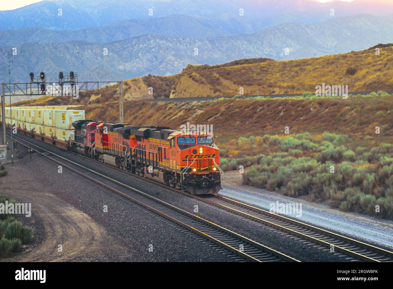 A golden glow at Hill 582: BNSF 8074 east makes its way on BNSF Main Track #1 in the Cajon Pass, Stock Photo