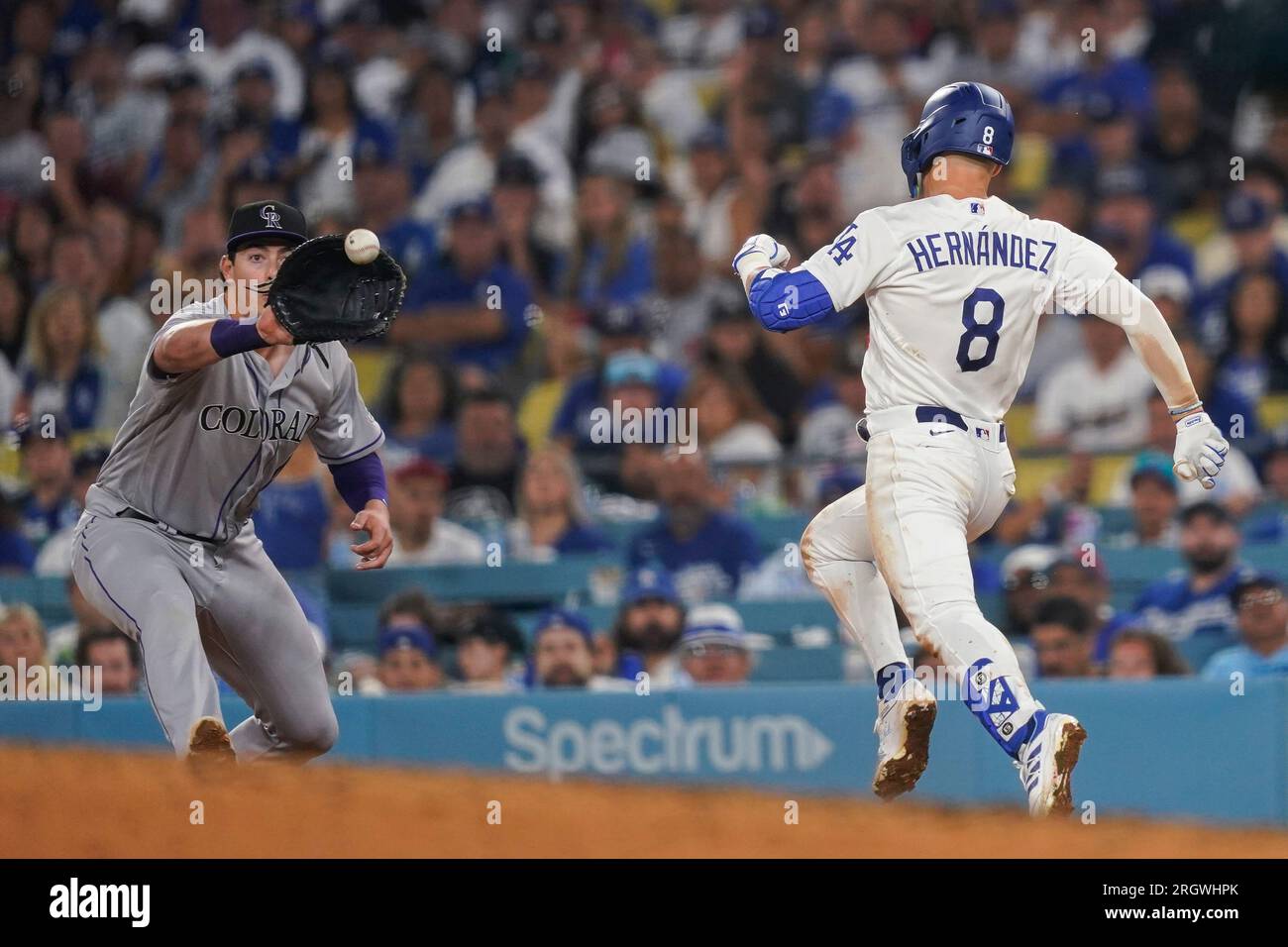 Los Angeles Dodgers' Enrique Hernandez (8) runs to first on a groundout as  Colorado Rockies first baseman Michael Toglia catches the throw during the  seventh inning of a baseball game Friday, Aug.