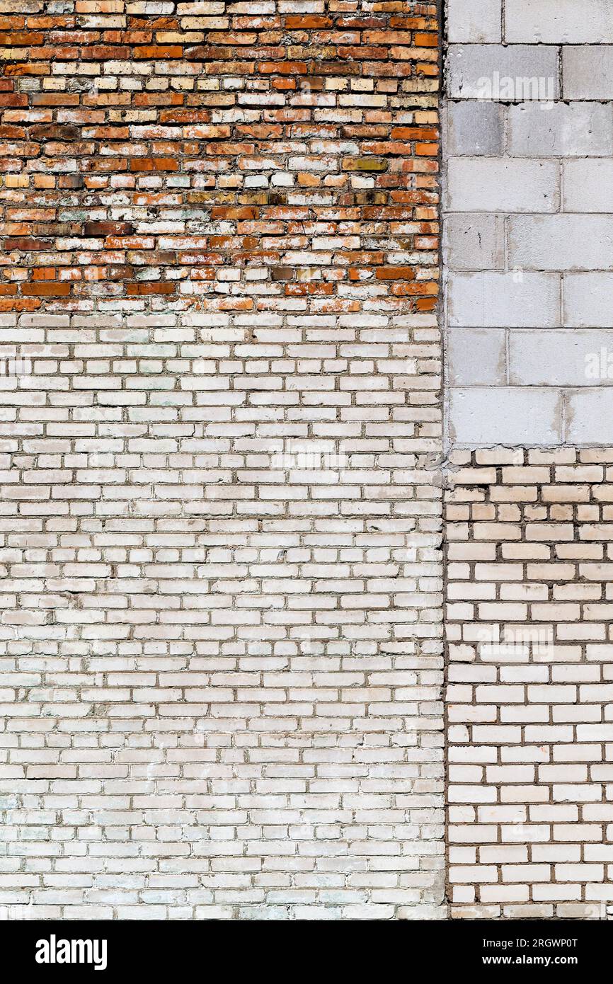 the wall of the building is made of different quality and types of bricks and blocks, mixed