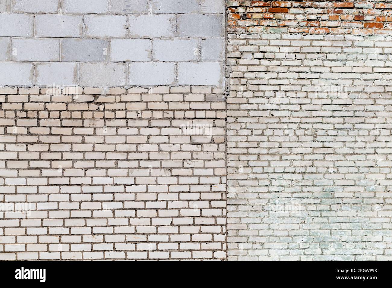 the wall of the building is made of different quality and types of bricks and blocks, mixed