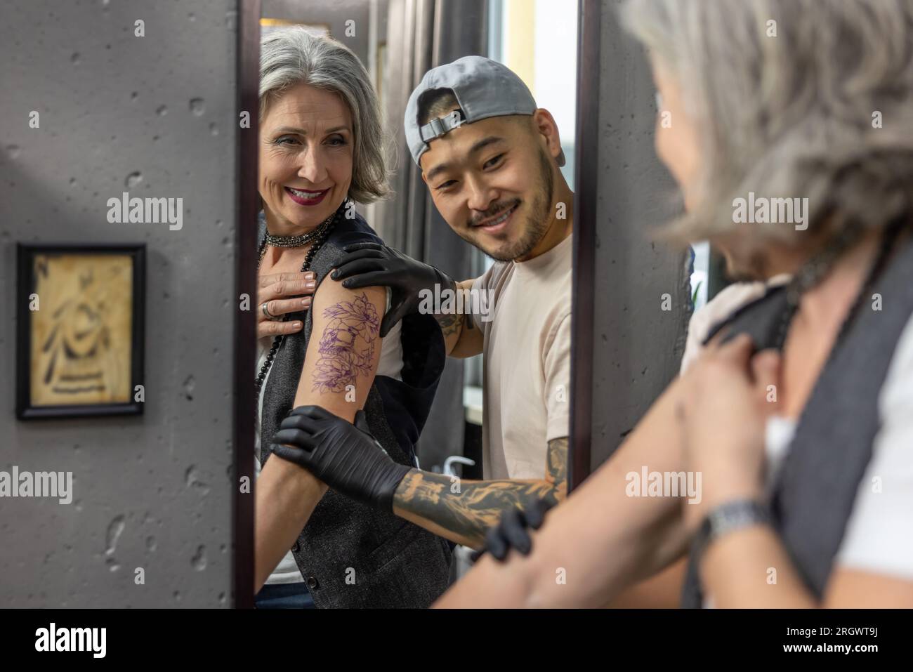Long-haired woman looking in the mirror at her new tattoo Stock Photo -  Alamy, image size:1300x957