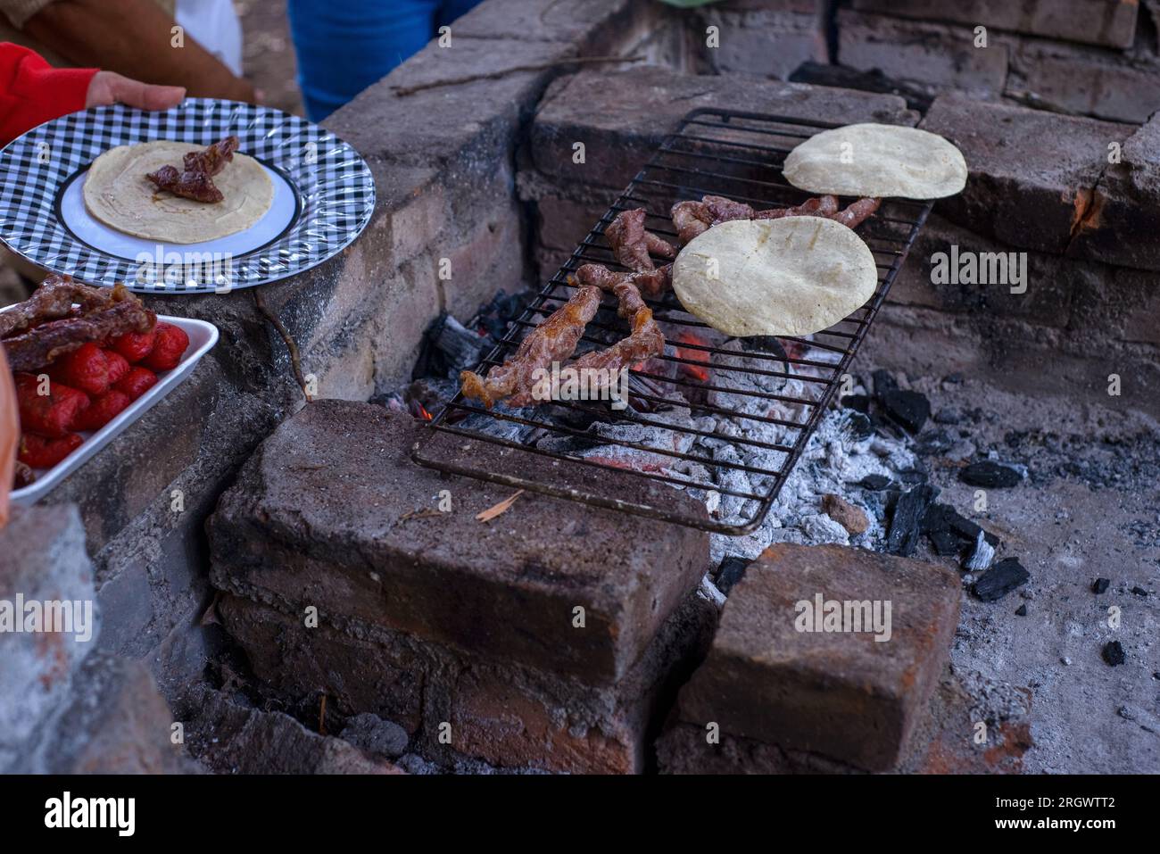 Grilled meat and tortillas on an improvised rustic grill Stock Photo